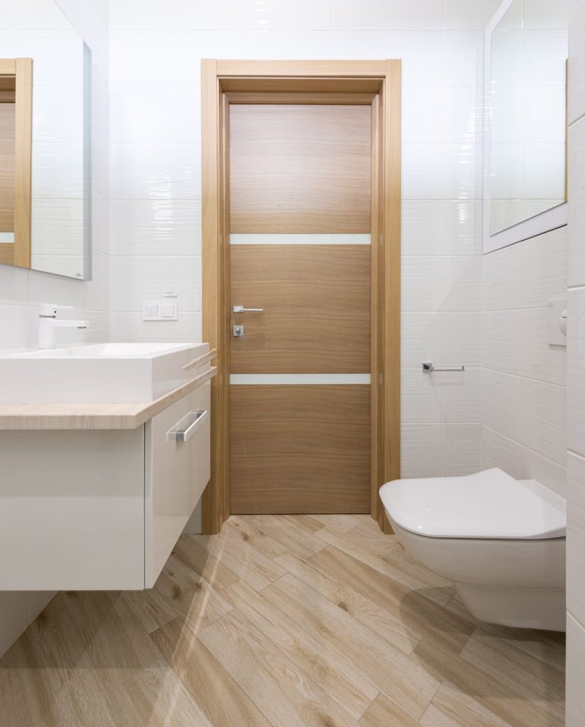 wooden door of contemporary white bathroom